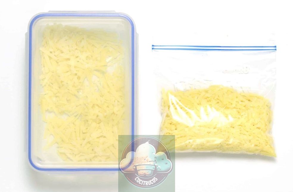 Comparación lado a lado de queso rallado almacenado en una bolsa para congelar VS queso rallado almacenado en un recipiente Tupperware.